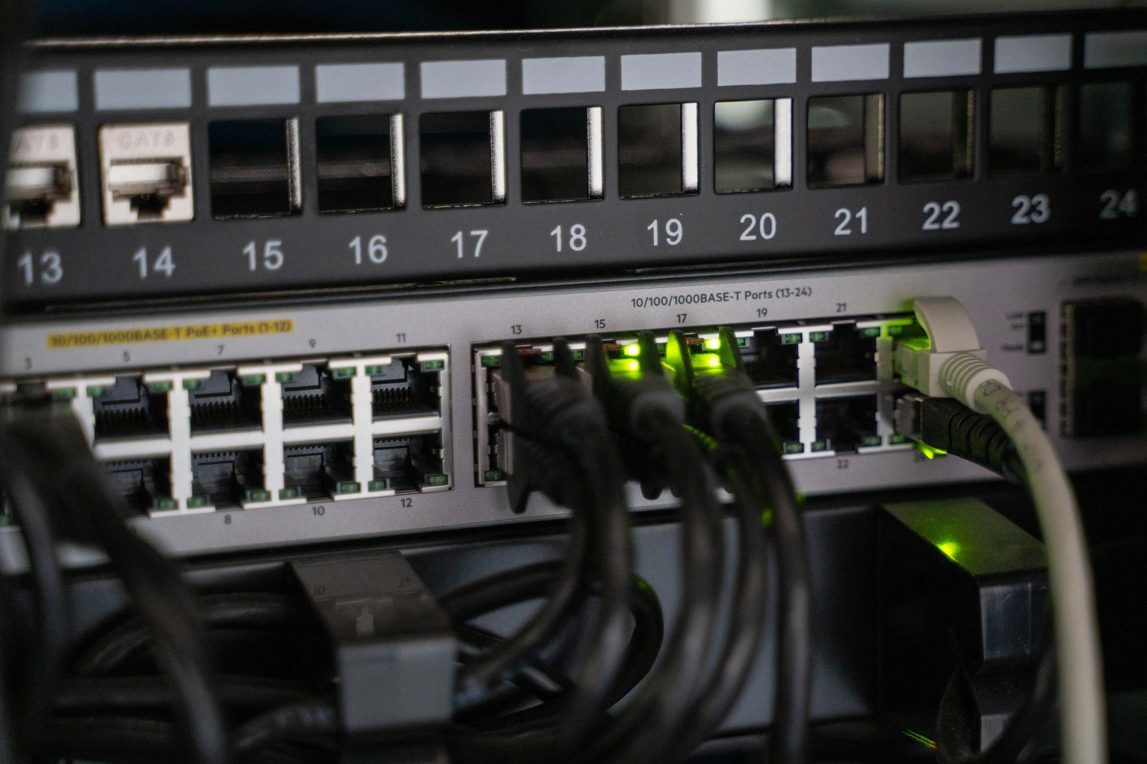 Wide view of a server room with racks and network cabling, networking equipment with connected cables